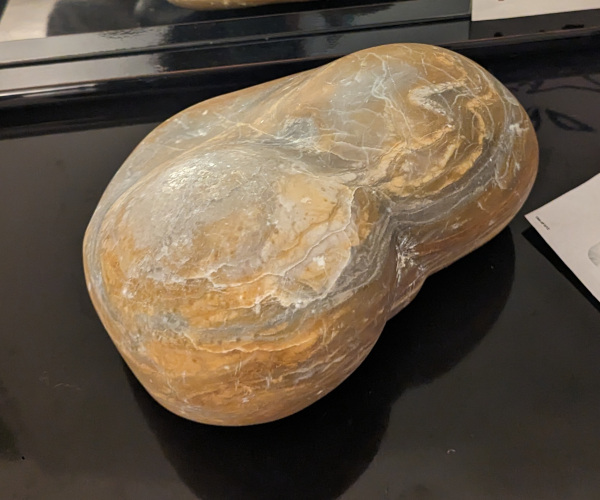 an abstract sculpture made from alabaster. it resembles a heart and a butt