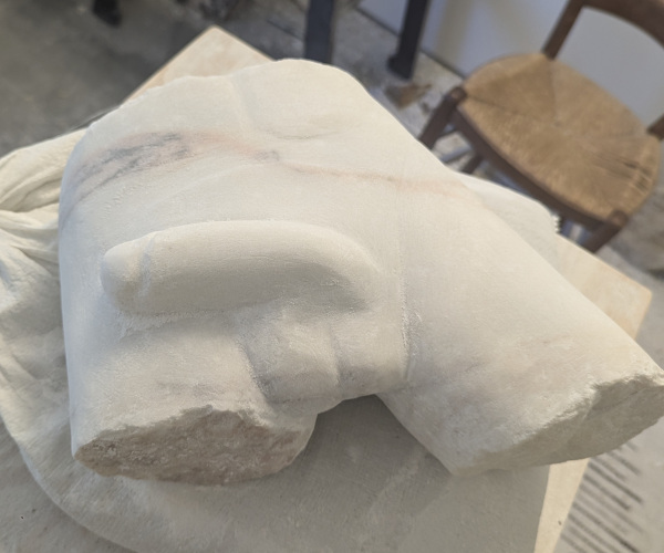 a sculpture made from marble showing a nude male figure